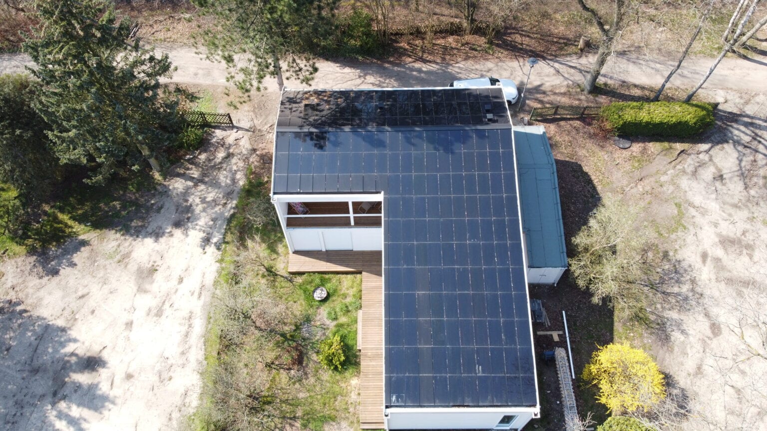 Ennogie-Solardach in Wandlitz: Drohnenaufnahme einheitliche Dachfläche aus Vogelperspektive, Bäume, Sträucher und Terrasse abgebildet
