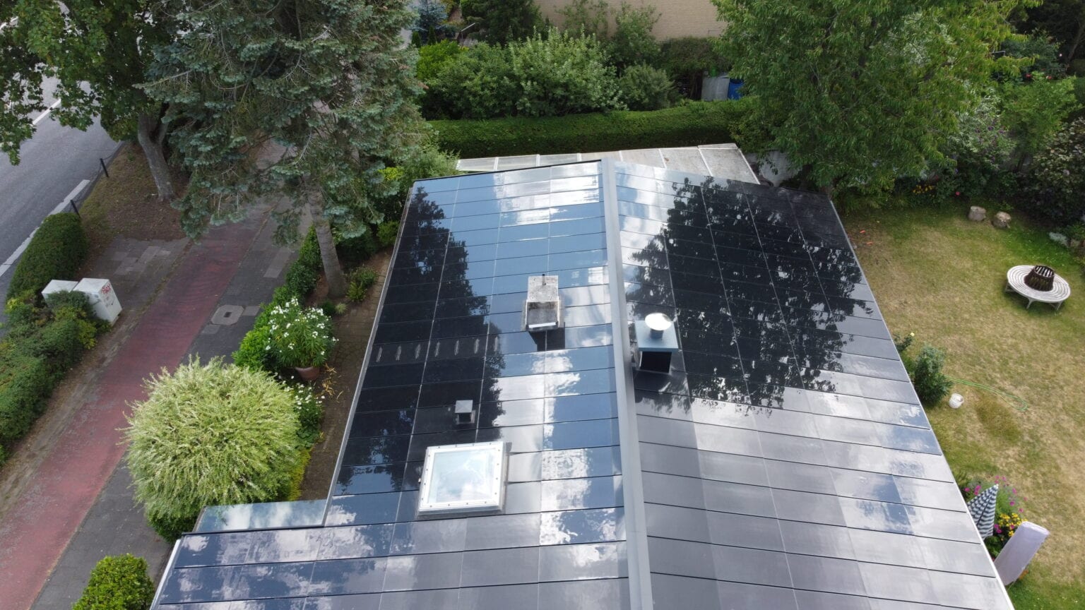 Ennogie-Solardach Bungalow in Köln: Vogelperspektive Dachfläche inklusive Dachfenster und Kamin