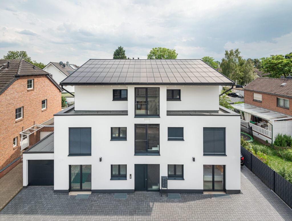 Ennogie-Solardach auf Neubau in Köln: Gesamtes Haus sichtbar, einheitliche Dachfläche, leichte Vogelperspektive