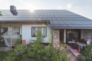 Ennogie-Solardach in Magdeburg: Großaufnahme bei Sonnenuntergang mit Terasse und Sträuchern im Vordergrund