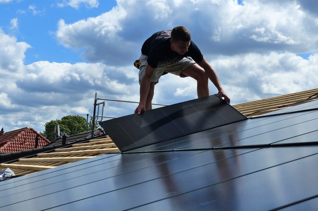 Monteur bringt Photovoltaikmodul für das Ennogie-Solardach auf Dachlattung an