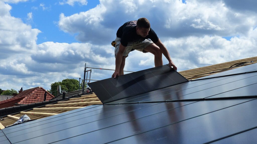 Monteur bringt Photovoltaikmodul für das Ennogie-Solardach auf Dachlattung an