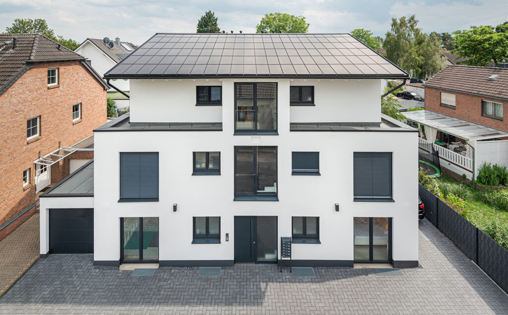 Ennogie-Solardach in Köln: Nahaufnahme des gesamten Hauses: Neubau Mehrfamilienhaus in weiß mit Ennogie-Solardach
